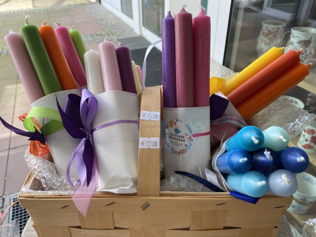 Bunte Stabkerzen in kleinen Geschenkarrangements
